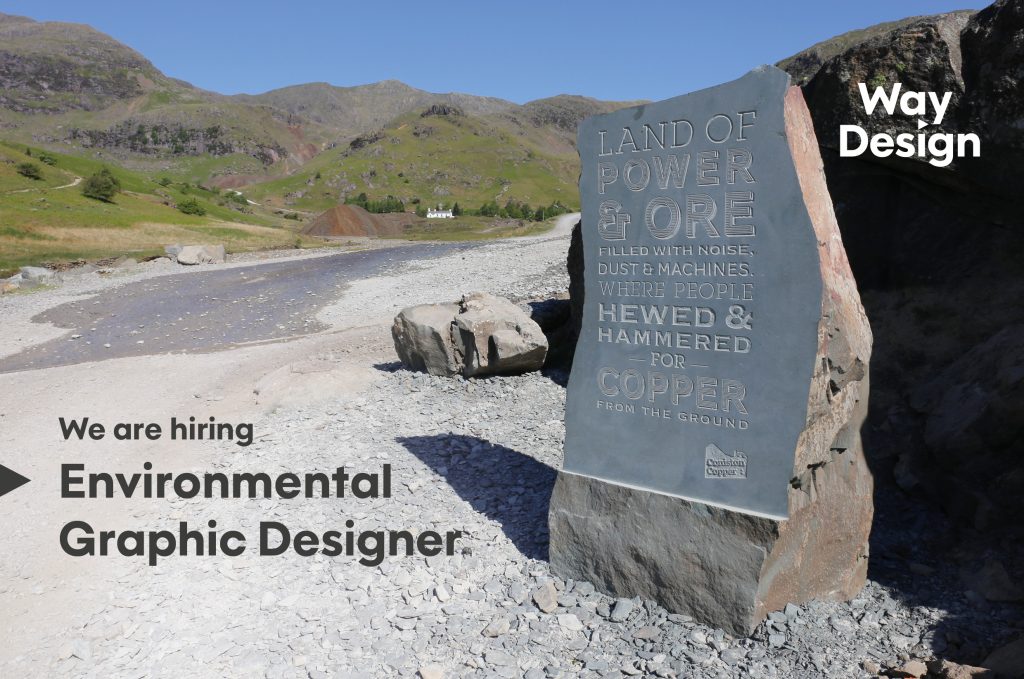 A carved slate monolith introduces visitors to Coniston Coppermines Valley. There is text on the left that says 'We are hiring. Environmental Graphic Designer'.